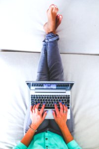 Woman lying and typing on laptop photo