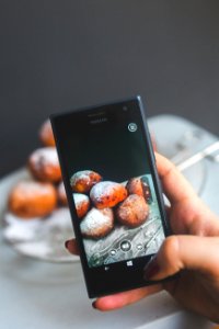 Woman hand taking picture of doughnuts photo