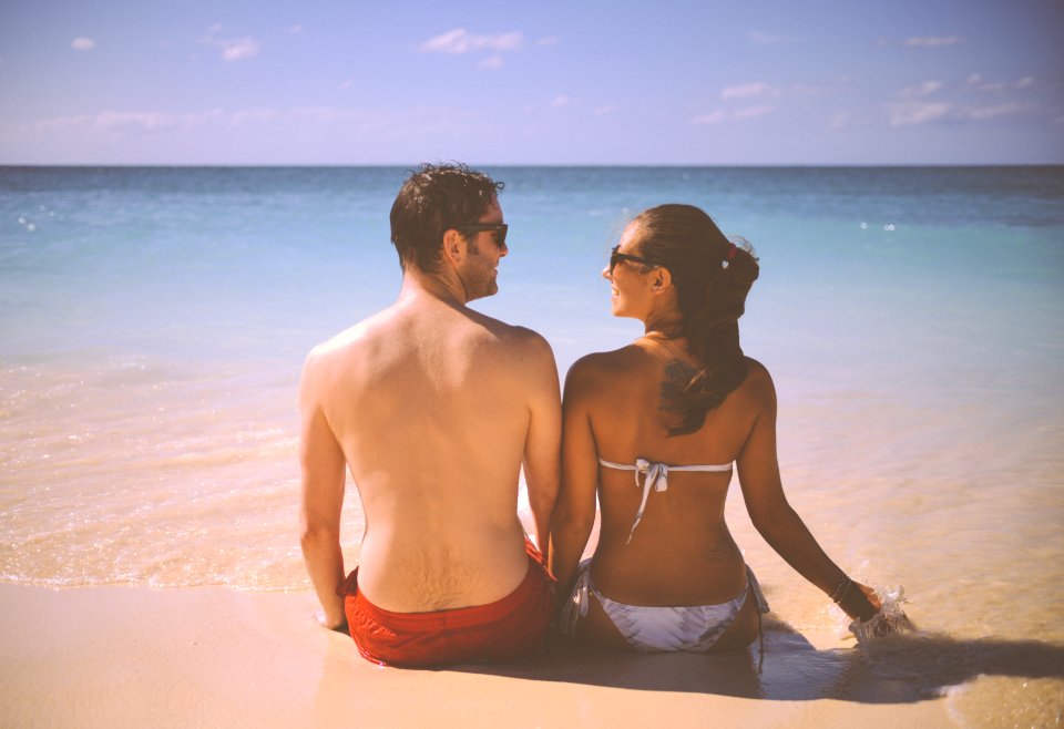 Man and Woman Sitting Beside Body of Water photo