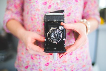 Old analog camera in woman's hands photo