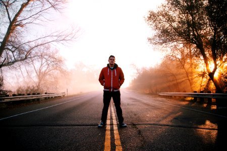 Man Standing on Gray Concrete Top Road Wearing Red and Black Zip-up Hooded Jacket photo