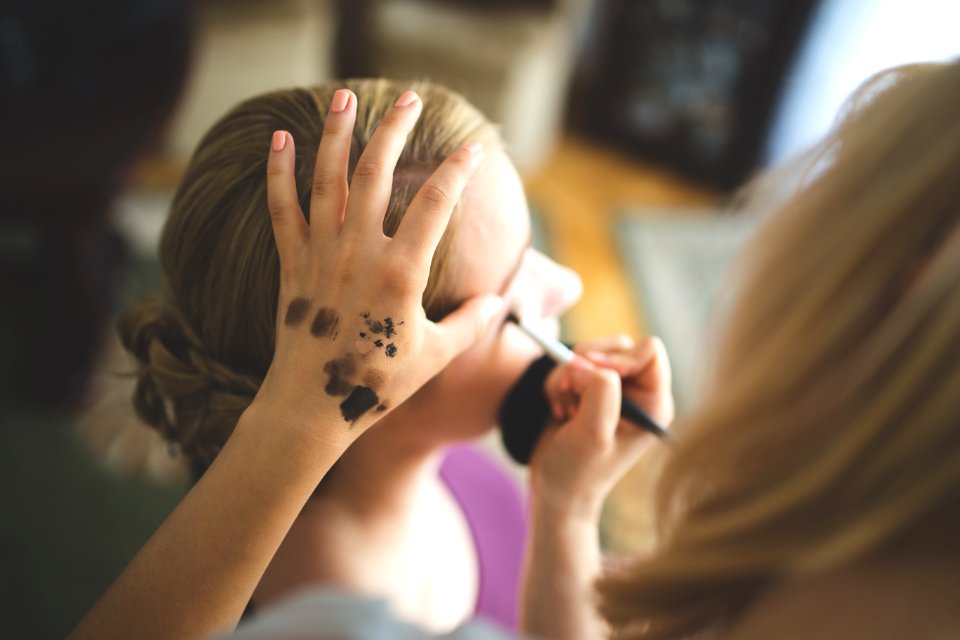 Make up artist applying shadow to a woman photo