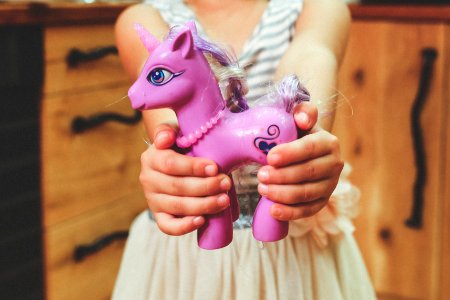Child holding unicorn toy photo
