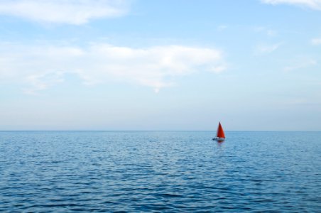 Orange Sailboat on Body of Water photo