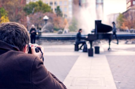 Man Taking a Photo of Person Playing Piano