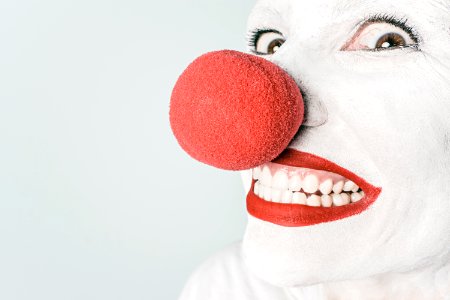 Smiling Person With Pink Lipstick and Red Nose Clown photo