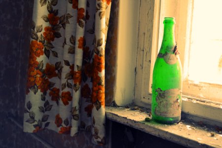 Green Glass Bottle Beside Window photo