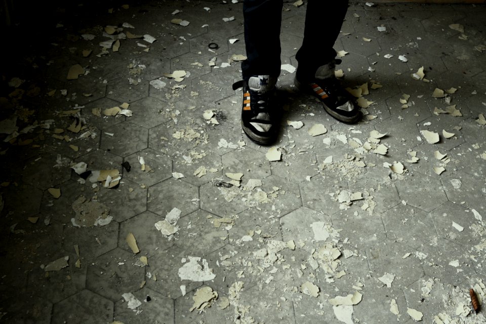 Person Standing on Gray Concrete Pavement Wearing Black-and-gray Lace-up Sneakers