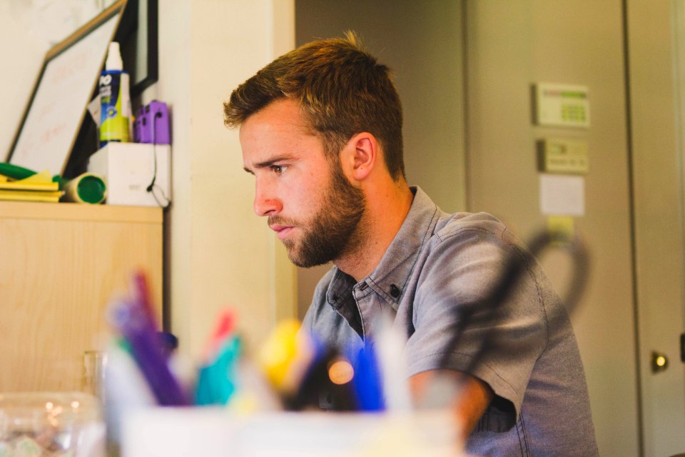 Selective Focus Photography of Man Sitting Near Desk photo