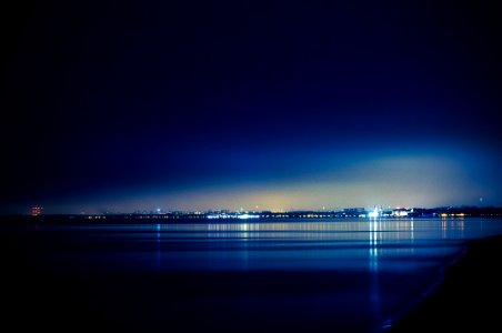 Landscape Photography of Buildings in Front of Calm Body of Water at Nighttime photo
