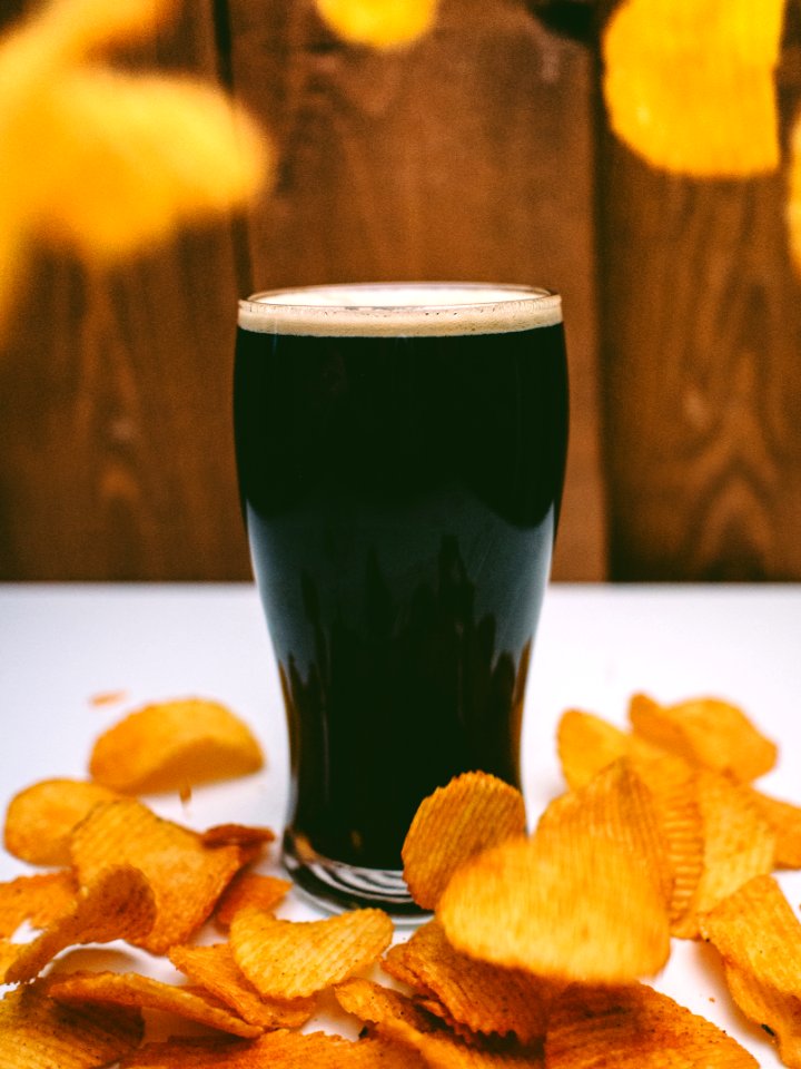 Clear Drinking Glass Filled With Green Liquid Surrounded by Chips photo