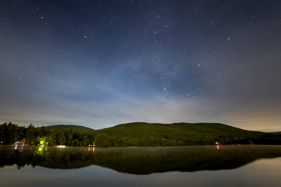 Green Mountain Near Body of Water at Night