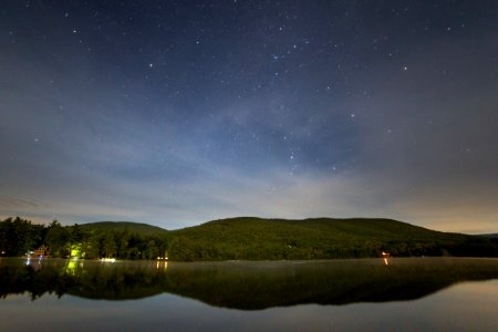 Green Mountain Near Body of Water at Night
