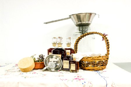 Brown Woven Basket Beside Clear Bottle on White Table Clothe photo