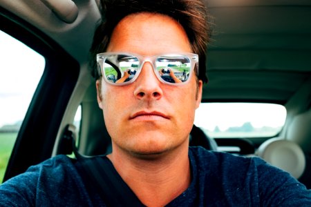 Close-up Photography of Man Wearing Sunglasses in Vehicle photo