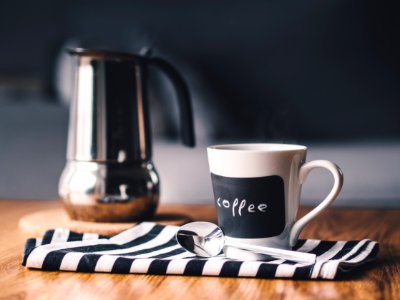 White Coffee Cup Next to Stainless Steel Spoon photo