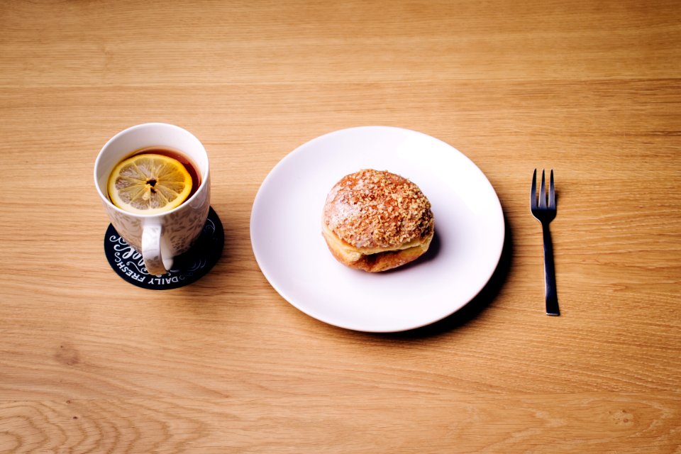 Burger on White Ceramic Plate Near White Ceramic Mug on Brown Wooden Surface