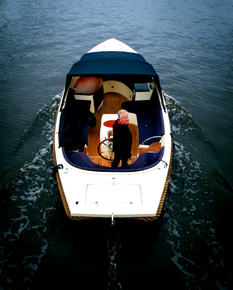 Man Riding on White and Brown Motorboat on Body of Water