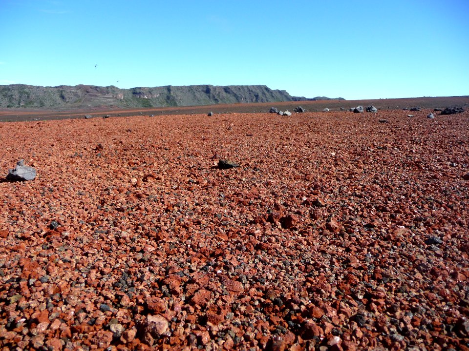 Les lapili rouges s'étalent à perte de vue, deux hélicoptè… 