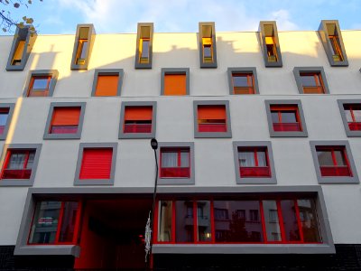 Immeuble aux fenêtres jaunes, oranges et rouges, au 99 rue… 