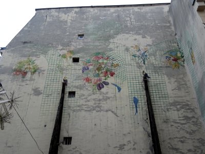 Un immeuble, avec des fruits, des fleurs et des perroquets… 