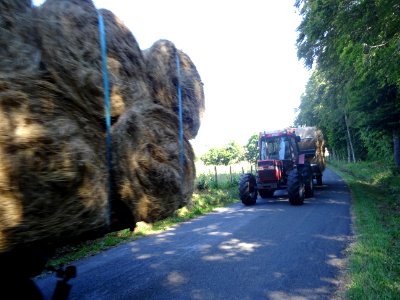 Deux tracteurs bien chargés de bottes de foin roulées, me … 