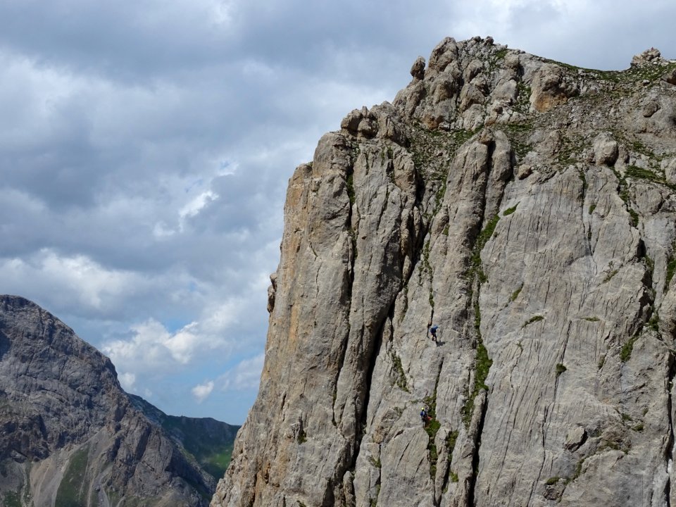 Dans la falaise en face, deux grimpeurs descendent en rapp… 