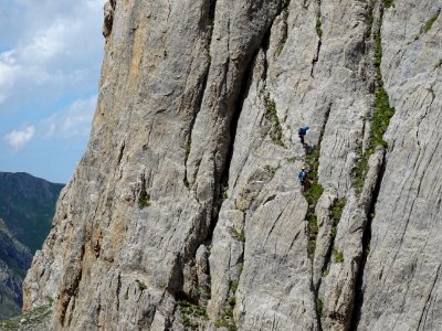 Dans la falaise en face, deux grimpeurs descendent en rapp… 