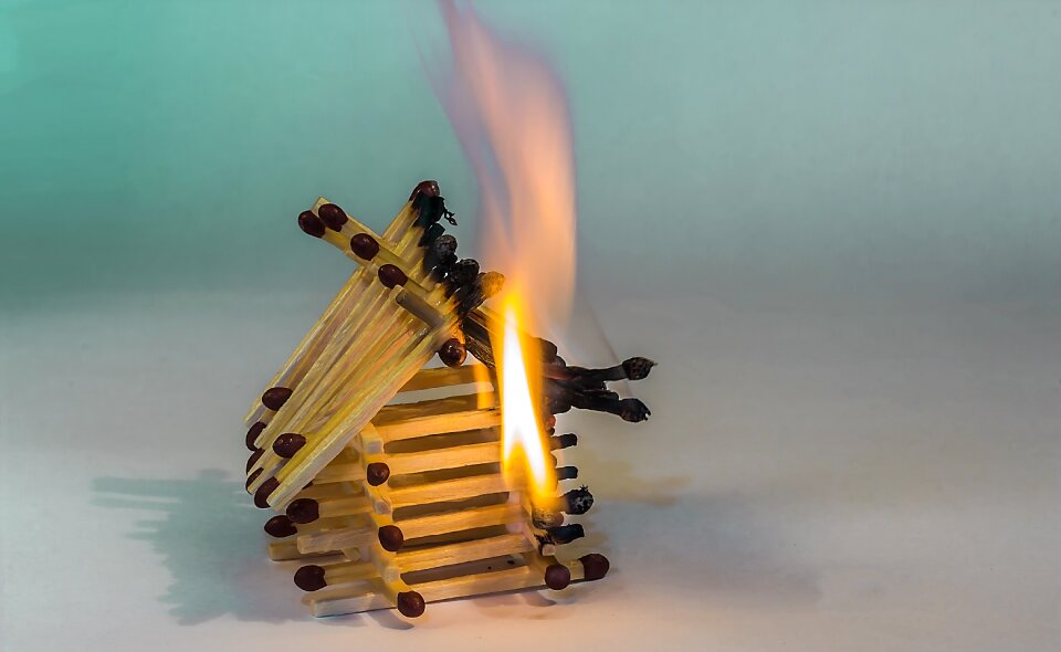 Burning matchstick house spent matchsticks charred matchsticks