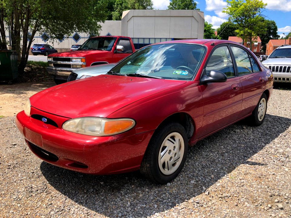 1997_Ford_Escort_LX_in_Toreador_Red_Metallic,_front_right,_7-3-2021