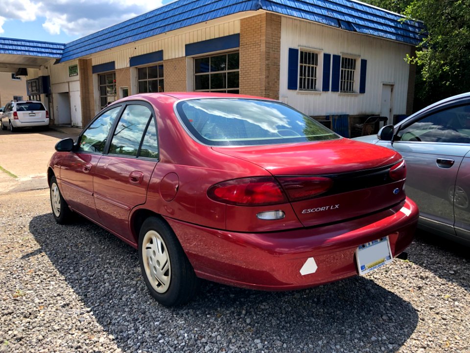1997_Ford_Escort_LX_in_Toreador_Red_Metallic,_rear_right,_7-3-2021