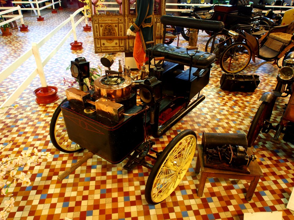 1885_De_Dion_Bouton_tricycle_with_front_mounted_boiler_and_water_tank_and_coal_chest_on_each_side_of_rear_wheel_at_the_Musée_Automobile_de_Vendée_pic-2