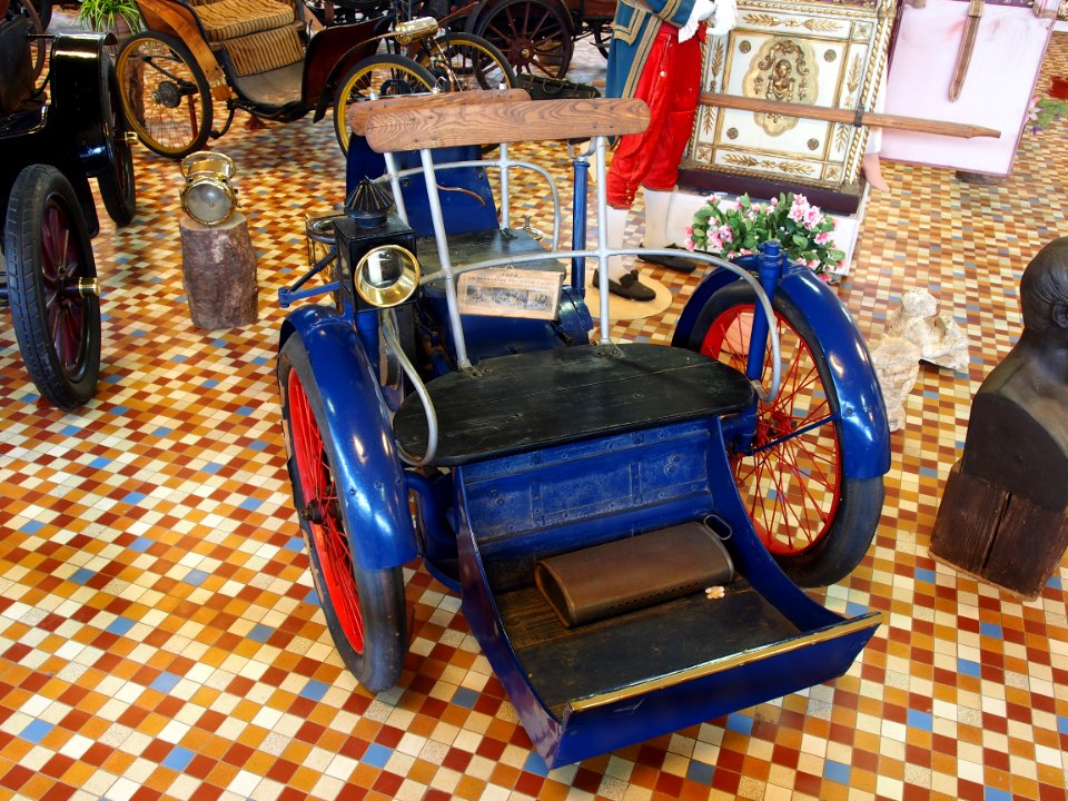 1898_Léon_Bollée_tricycle_car,_single_horizontal_cylinder,_burner_ignition_and_flat_belt_transmission_at_the_Musée_Automobile_de_Vendée_pic-2