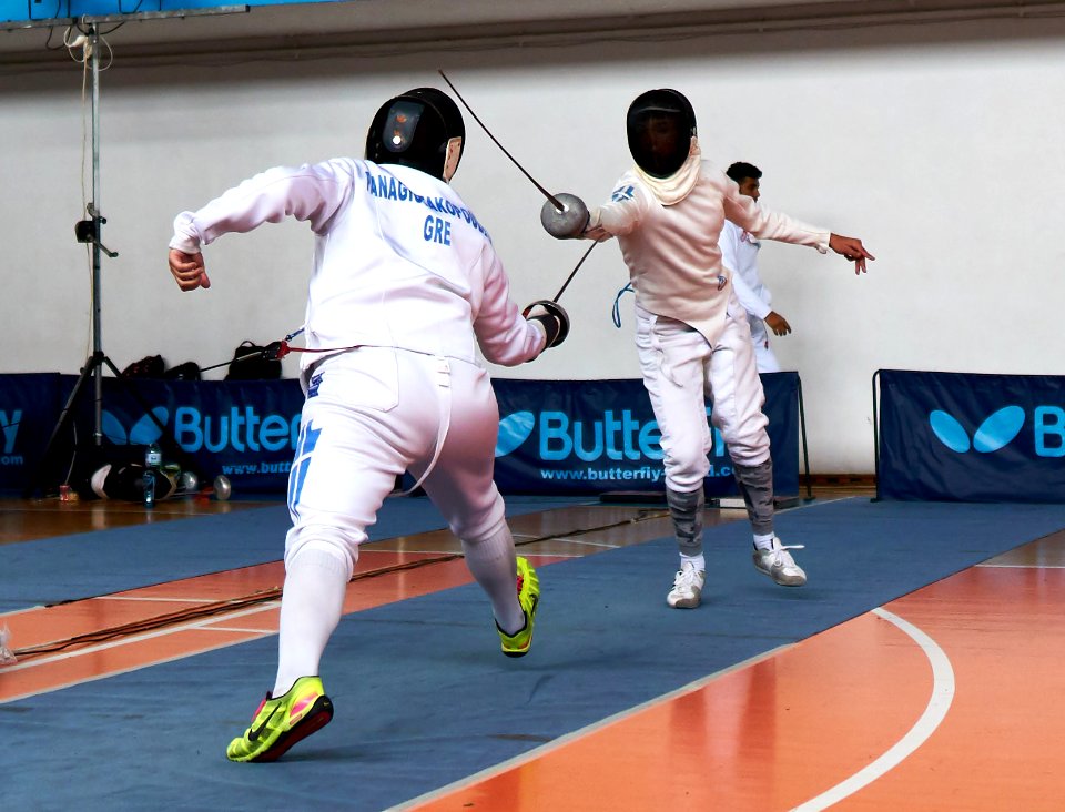 2nd_Leonidas_Pirgos_Fencing_Tournament._The_fencer_on_the_right_is_performing_a_flick_and_he_is_going_to_score_a_touch