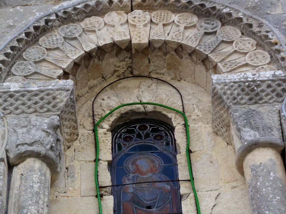 Église_Notre-Dame-de-l'Assomption_de_Poursay-Garnaud,_stèles_discoidales_et_chapiteaux_autour_d'une_fenêtre