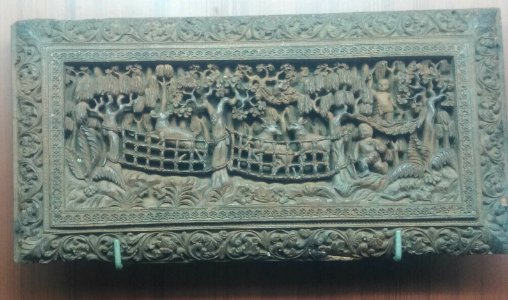 A_carved_piece_depicting_human_figures_trees_and_animals photo