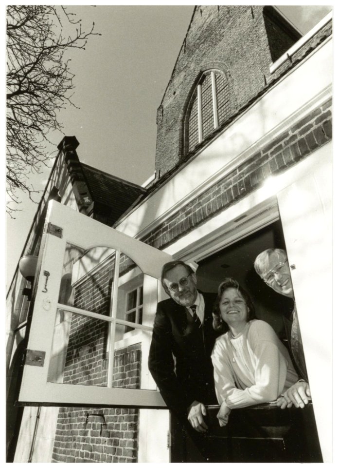 A._vander_Steur,_G._van_de_Ree-Scholtens_en_S._Groenveld_kijken_uit_het_raam_van_het_Gemeente-archief_aan_de_Jansstraat._NL-HlmNHA_54035301