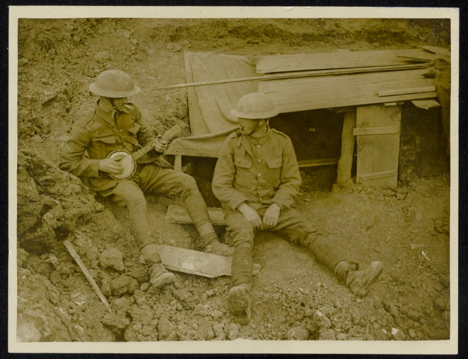 A_little_music_at_the_entrance_to_their_dug_out,_Bestanddeelnr_158-0956