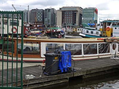 A_view_on_old_boats_and_houseboats,_in_front_of_the_new_buildings_on_Oosterdokseiland_in_Amsterdam,_by_FotoDutch_in_2013 photo