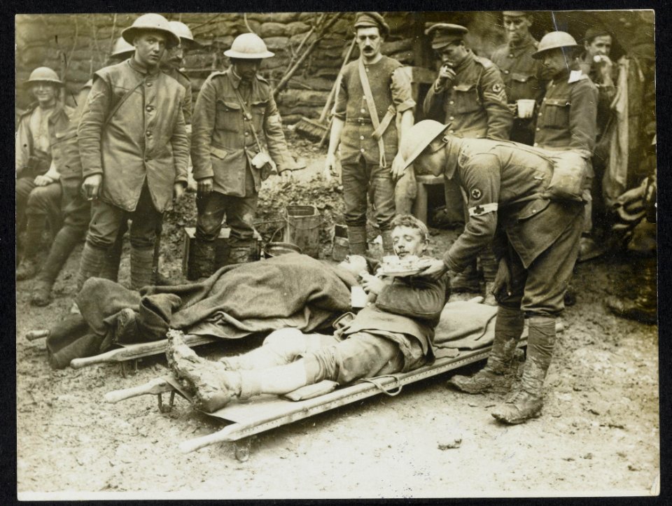 A_sandwich_for_one_of_our_wounded_at_the_Dressing_station,_Bestanddeelnr_158-0985