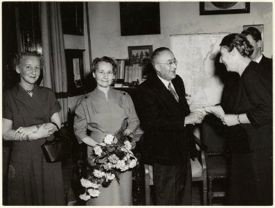 Afscheid_van_A.C._Sandijck._Archivaris_mevrouw_Kurtz_overhandigt_een_geschenk._Links_en_rechts_de_heer_en_mevrouw_Groen._NL-HlmNHA_54001235