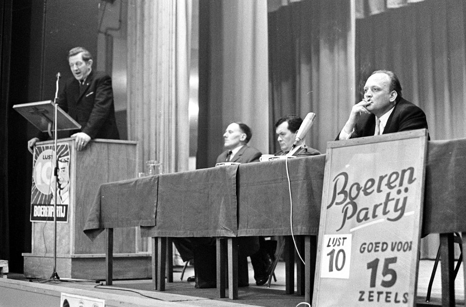 Affiches_Boerenpartij_goed_voor_15_zetels,_links_Koekoek_tijdens_vergadering_Den,_Bestanddeelnr_920-0505
