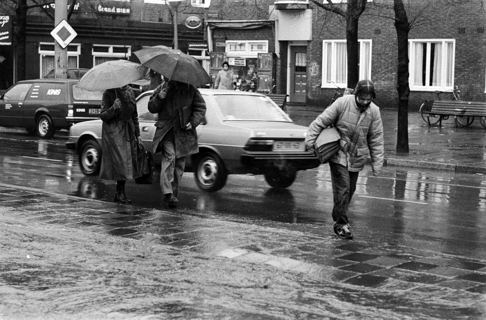 Afgelopen_dagen_heeft_het_bijna_aan_een_stuk_door_geregend_mensen_lopen_langs_vluchtheuvel_in_Amsterdam,_Bestanddeelnr_931-3657