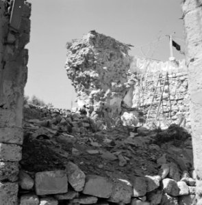 Afgebrokkeld_stuk_muur,_erachter_hangt_wasgoed_aan_de_lijn,_Bestanddeelnr_255-2546