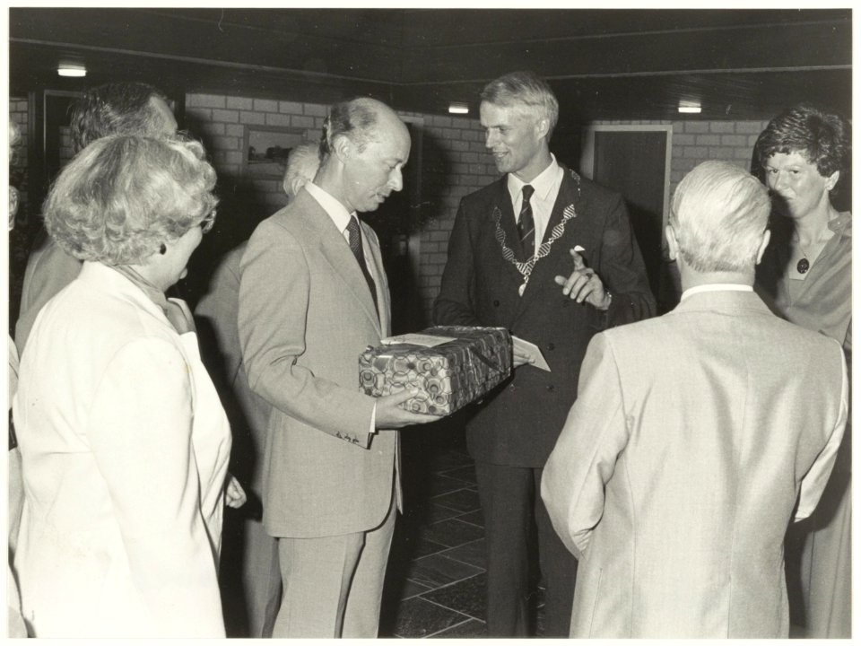 Afgebeeld_is_burgemeester_J._de_Widt_tijdens_zijn_afscheidsreceptie_op_23_augustus_1983_in_het_gemeentehuis_van_Bennebroek_aan_de_Bennebroekerlaan._Hem_wodt_hier_door_N.N._een_cadeau_aangebo,_NL-HlmNHA_54016686