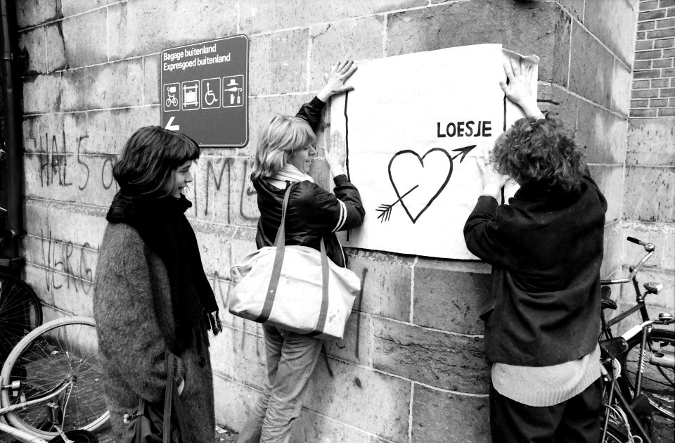 Affiches_plakken_van_actiegroep_Loesje_bij_het_station_in_Haarlem