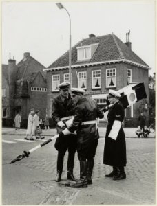 Agenten_plaatsen_een_verplaatsbaar_verkeersbord._NL-HlmNHA_54004164