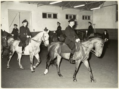 Agenten_te_paard_tijdens_de_training_in_de_manege_aan_de_Wagenweg._NL-HlmNHA_54004165