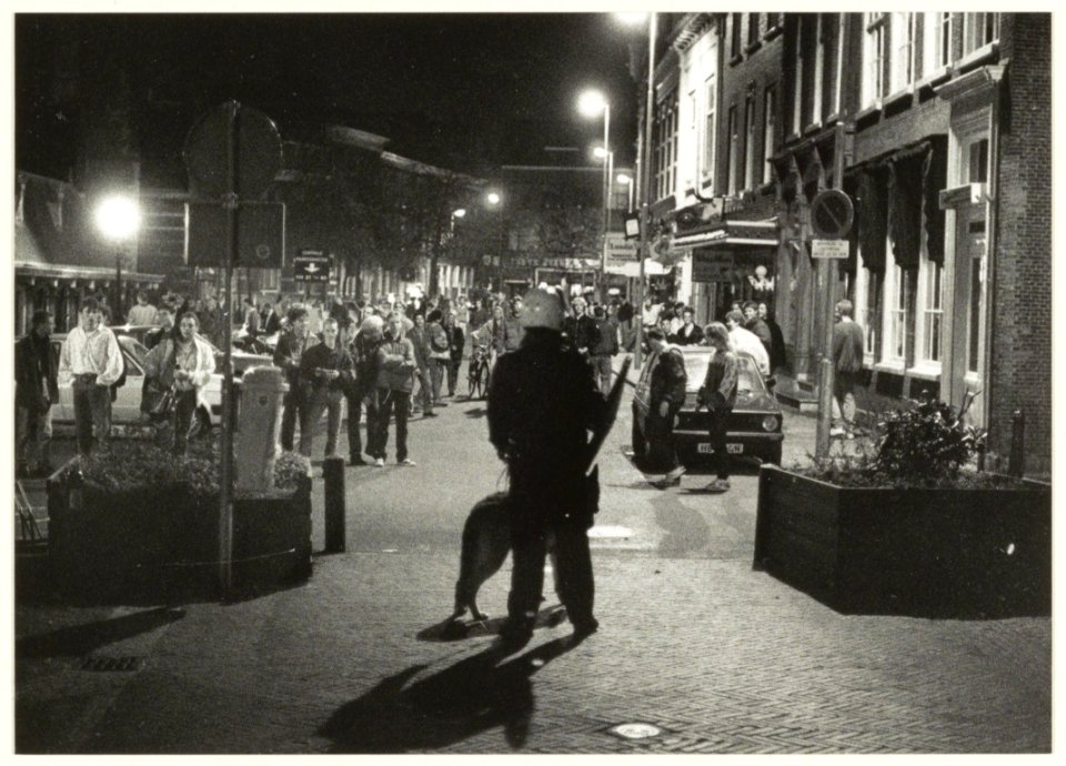 Agent_van_de_Mobiele_Eenheid_houdt_bezoekers_op_de_Oude_Groenmarkt_in_het_oog_in_verband_met_opstootjes_naar_aanleiding_van_de_nieuwe_sluitingstijd_voor_café's