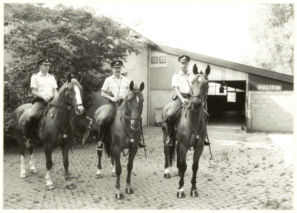 Agenten_te_paard_voor_de_politie_manege_aan_de_Wagenweg._NL-HlmNHA_54032265